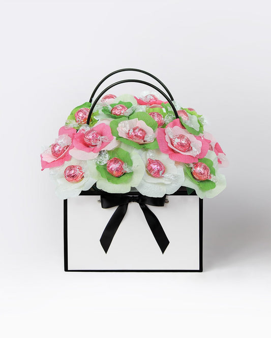 Strawberry Matcha Bloom Box with handcrafted chocolate flowers in pink, cream, and green matcha tones, presented in a luxury black and white gift basket.